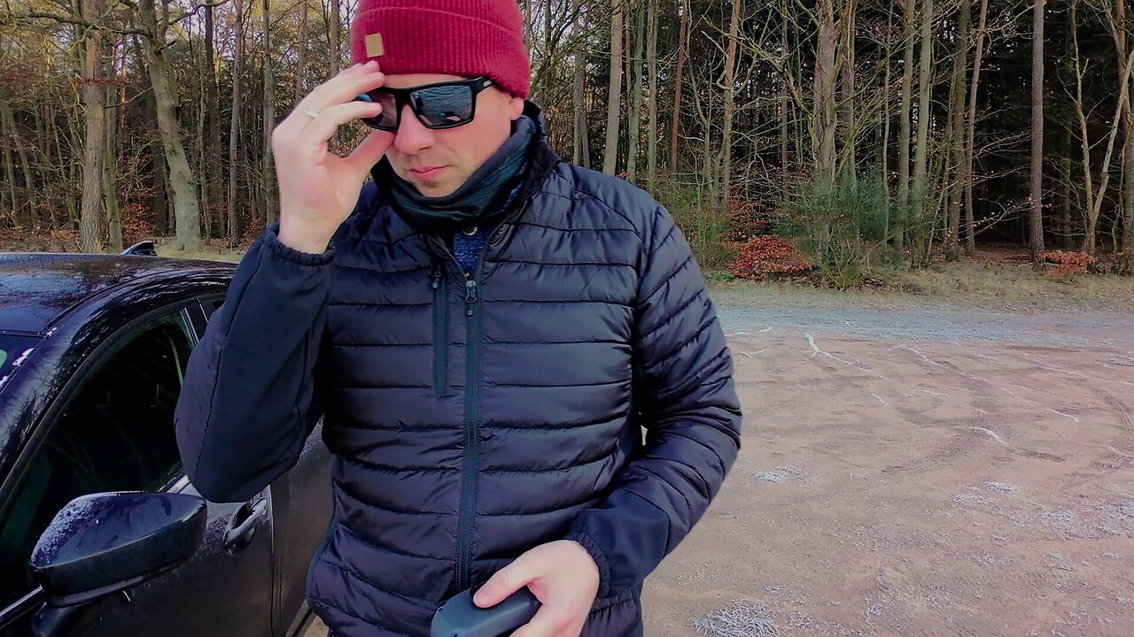 Markus Winkler mit Fernsteuerung neben seinem Auto, kurz vor dem Start der Drohne